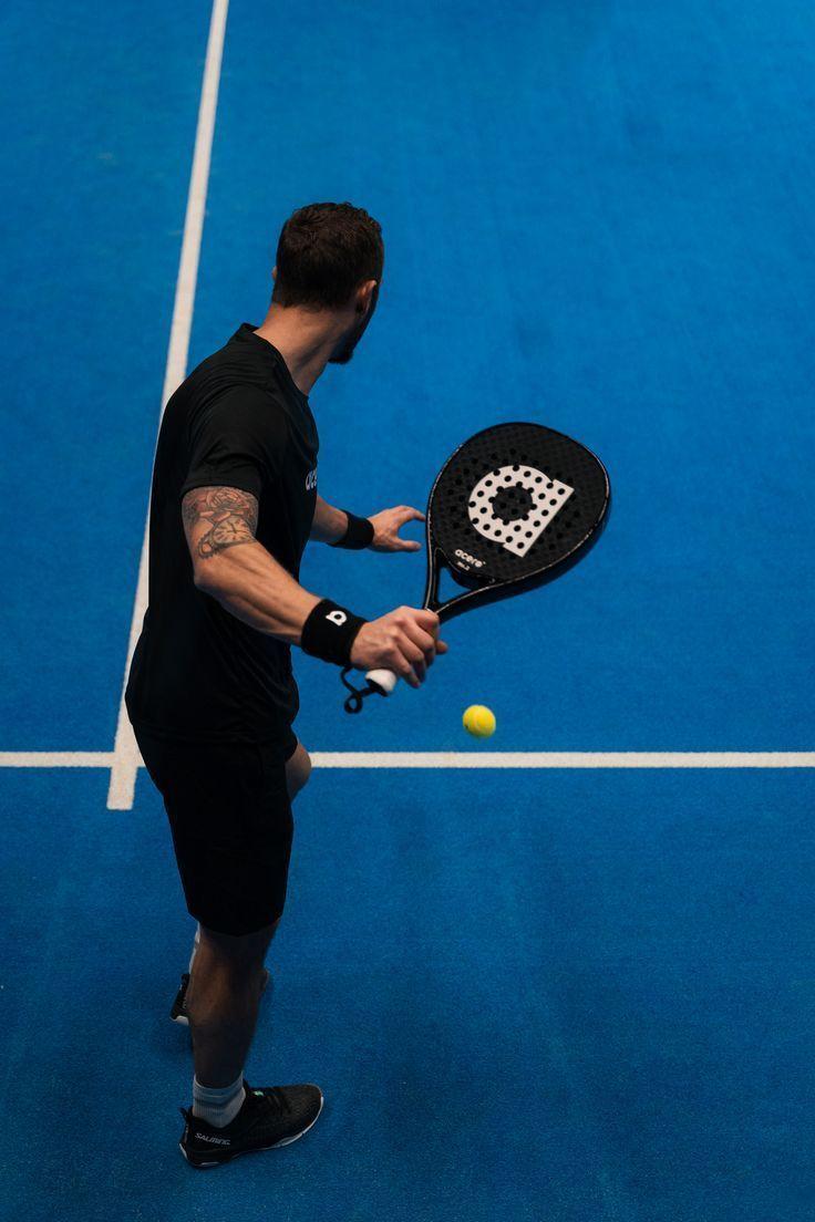 Joueur de padel prêt à servir sur une piste bleue