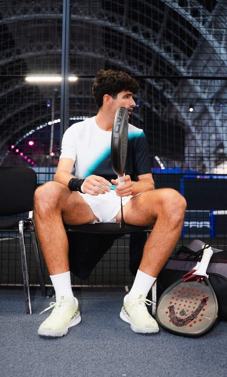 Joueur de padel assis sur un banc, raquette en main