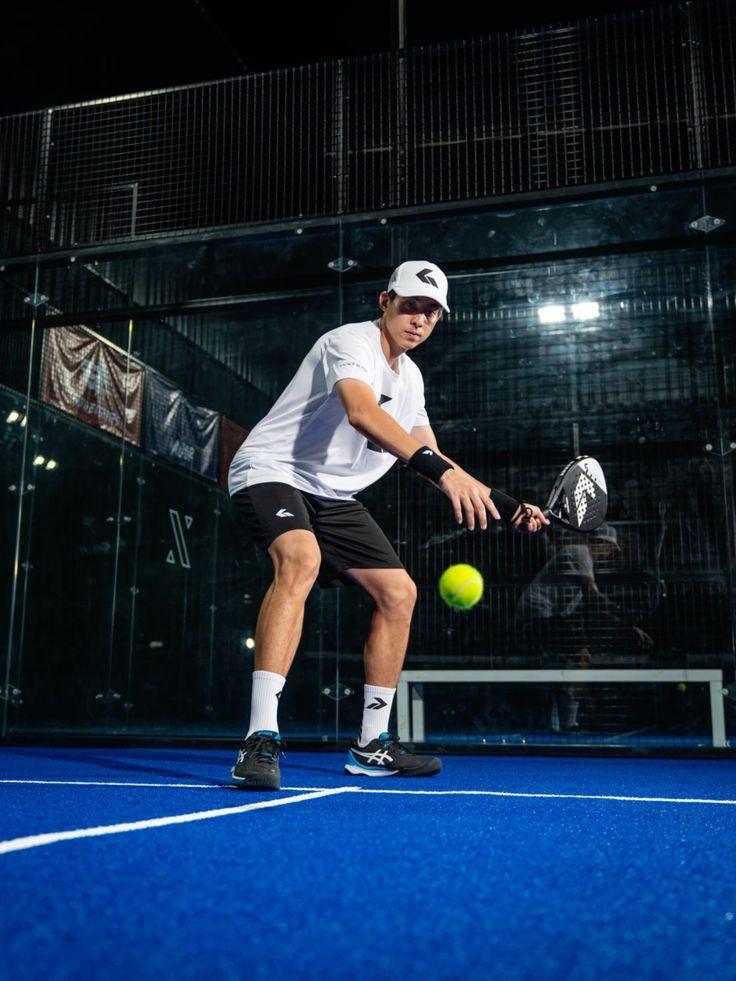 Joueur de padel frappant la balle sur une piste en salle