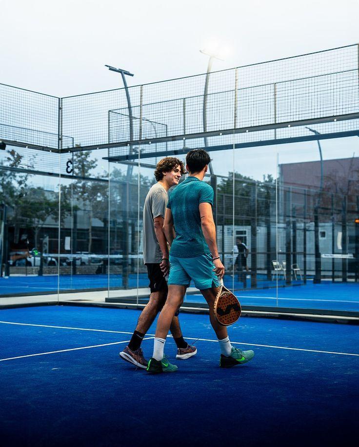 Deux joueurs de padel côte à côte sur une piste bleue