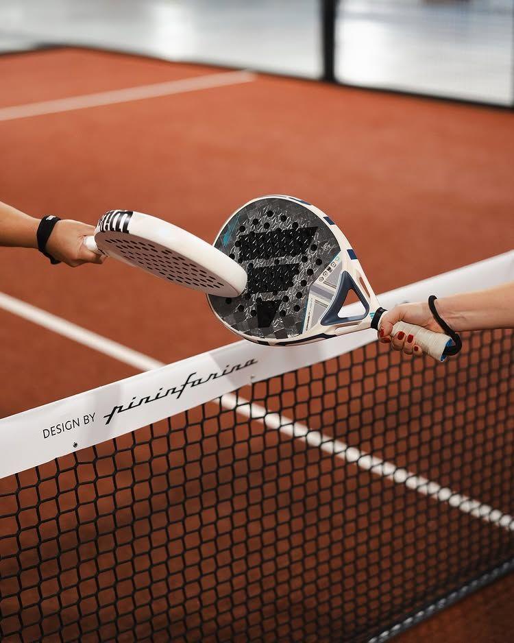 Raquette de padel posée sur le filet d’une piste