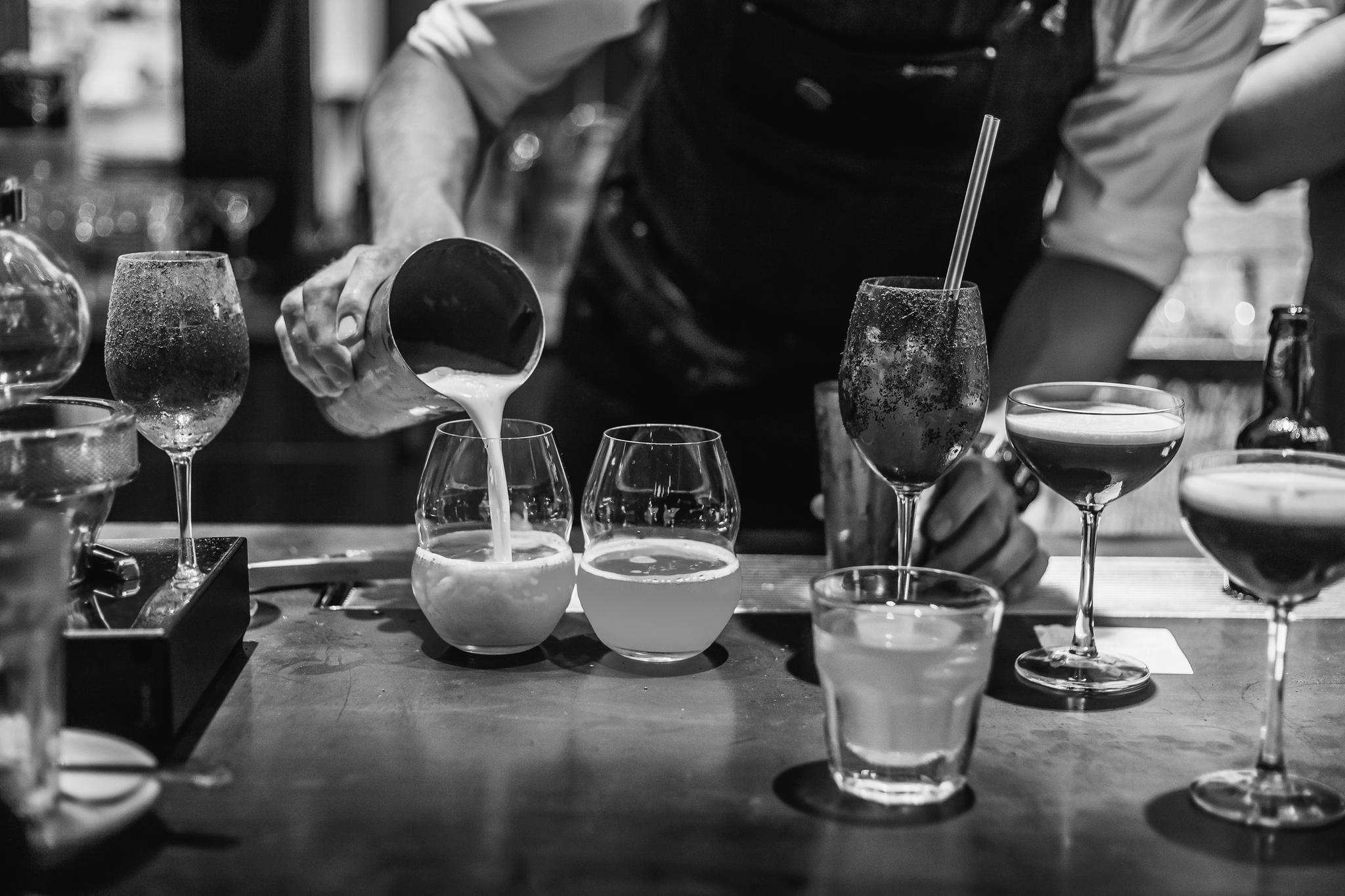 Barman versant un cocktail au comptoir